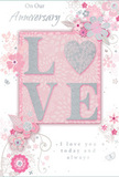 This anniversary card is captured in a close, detailed view, as if resting beside a hand-tied bouquet on a table in Abbots Langley, ready to be gifted. The design centres around the word LOVE, each letter softly raised from the surface and dusted with fine glitter that shimmers in blush pink, pearly white, and silver. The letter O becomes a delicate heart shape, its silver texture catching the light with the same subtle sparkle you might see in a carefully wrapped bouquet ribbon. Surrounding this focal point, a cloud of pastel florals blossoms across the card: gentle blooms in blush, mauve, and soft ivory, their petals painted with a watercolour softness and outlined in fine, flowing lines. These stylised flowers and swirling vines echo the grace of an English spring garden, reminiscent of the blossom trees and cottage gardens tucked around Abbots Langley. Tiny flourishes-curled tendrils, floating petals, and small, almost translucent butterflies-add a sense of movement, like petals stirred by a light breeze on a quiet anniversary walk. The background is a muted, powdery pink, creating an intimate, romantic backdrop that lets the silvery details glint without overwhelming the eye. In elegant, understated script, phrases such as On Our Anniversary and I love you today and always appear, their flowing type adding a personal, heartfelt touch. The composition feels like a keepsake: soft, reflective, and deeply affectionate, much like receiving fresh flowers and a thoughtful card delivered to your door anywhere across Abbots Langley.